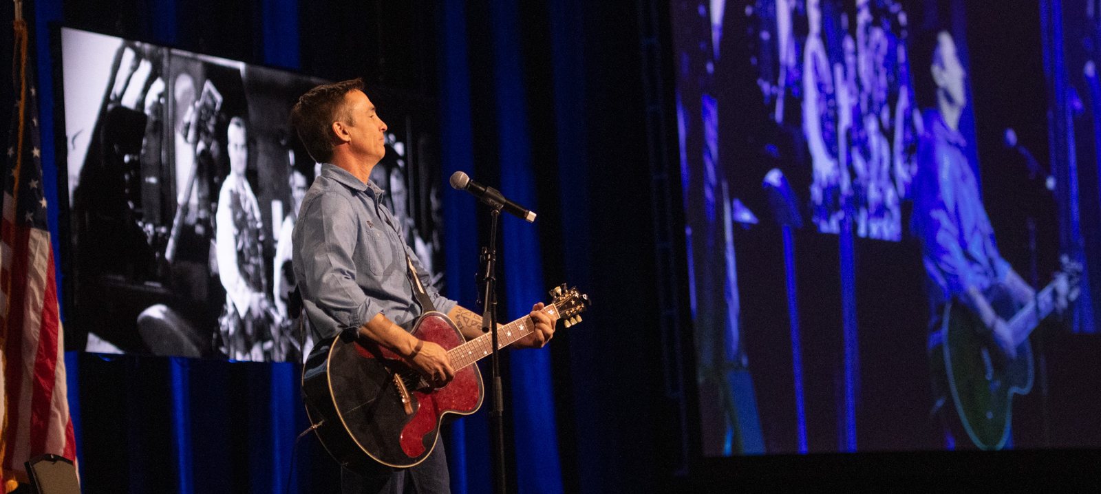 Keni Thomas playing guitar to close a keynote