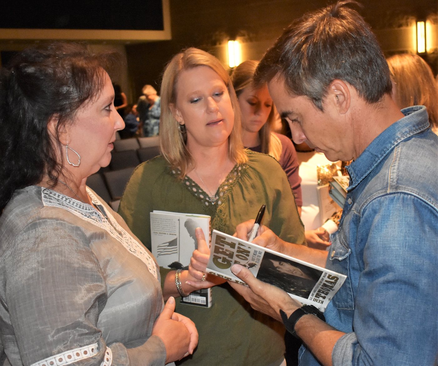 Keni Thomas signing Get It On! for attendees after a keynote